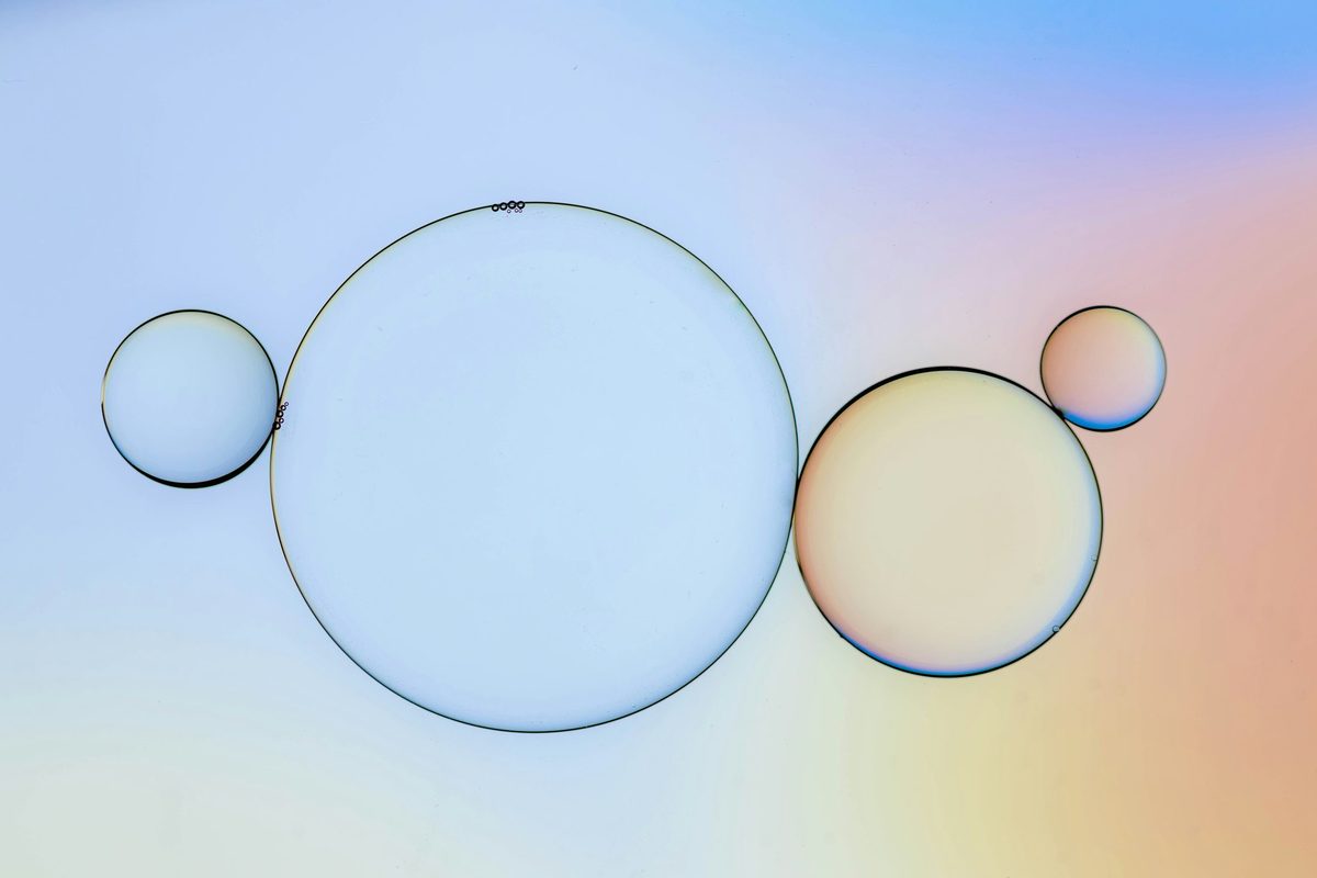 Burbujas de distinto tamaño flotando sobre el mismo plano, con reflejos de color en su superficie: la misma lógica que un bubble chart usa para codificar una tercera variable mediante el área del círculo