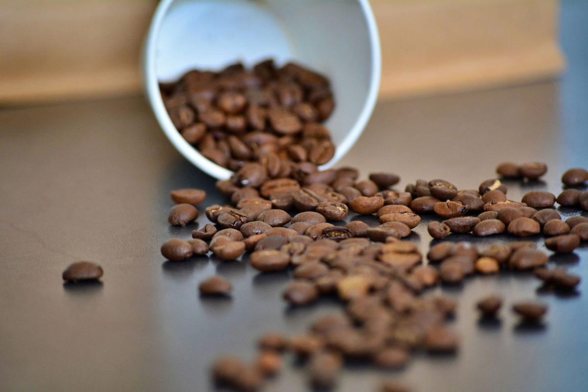 Granos de café derramados de una taza sobre una mesa, dispersos de forma genuinamente aleatoria y a veces superpuestos: la misma anatomía de un strip plot, donde la dispersión no sigue ningún cálculo de empaquetado, a diferencia de un bee swarm